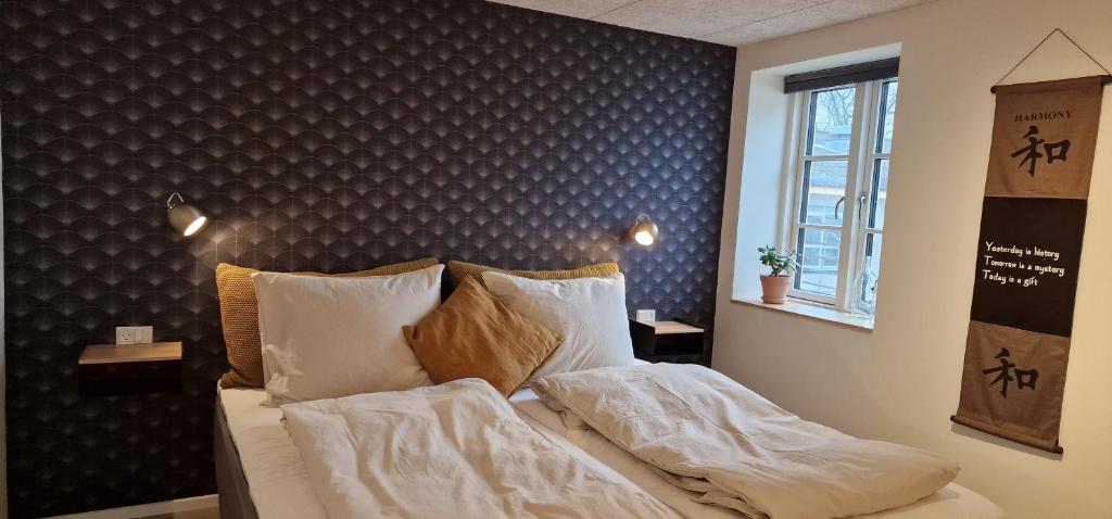 克内贝尔Molsgaarden的一间卧室配有带白色床单和枕头的床。