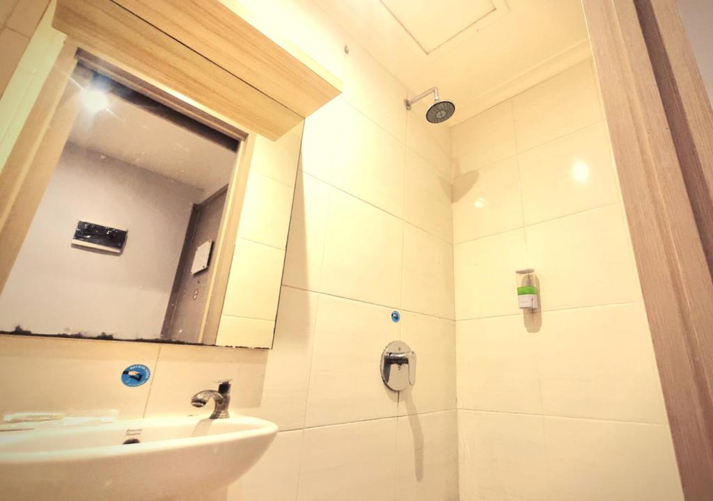 Rawabokor DuaCentral Front One Inn Jakarta Airport的一间带水槽和镜子的浴室