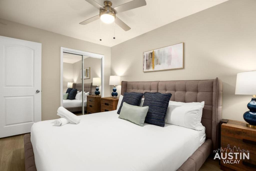 奥斯汀Remodeled Apt w Gated Community and In-Unit Laundry的卧室配有带蓝色枕头的大型白色床