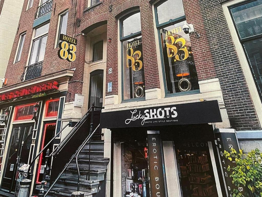 阿姆斯特丹83号酒店的城市街道上一座砖砌建筑,有商店