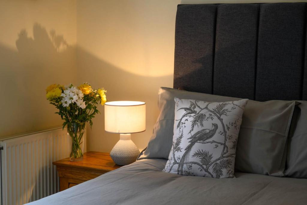 邓凯尔德The Farmhouse B&B的一间卧室,配有一张带花瓶和灯的床