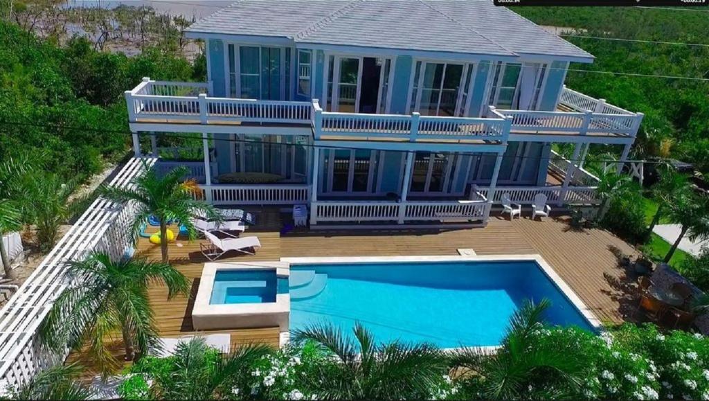 总督港Sea Walk home的蓝色的房子,前面设有一个游泳池