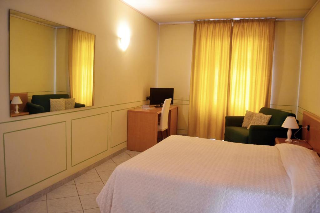 Villanova dʼAstiAlbergo del muletto的一间医院间,配有一张床、两把椅子和一张书桌