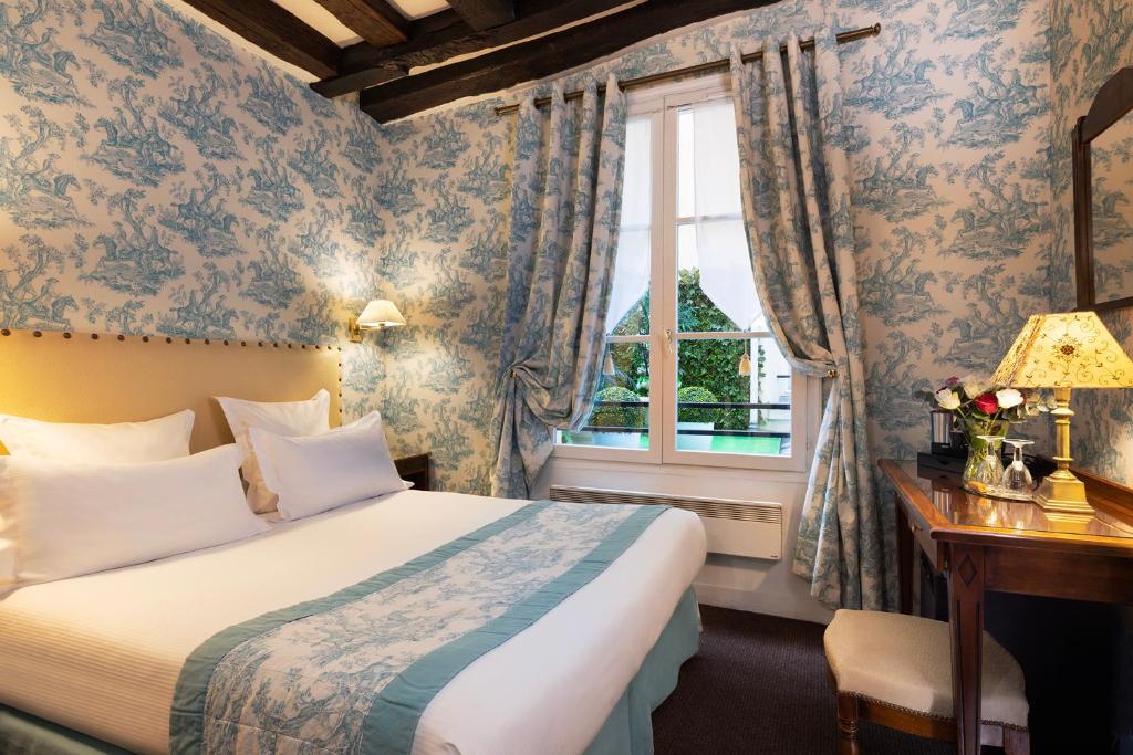 巴黎驿站酒店的一间卧室设有一张床和一个窗口
