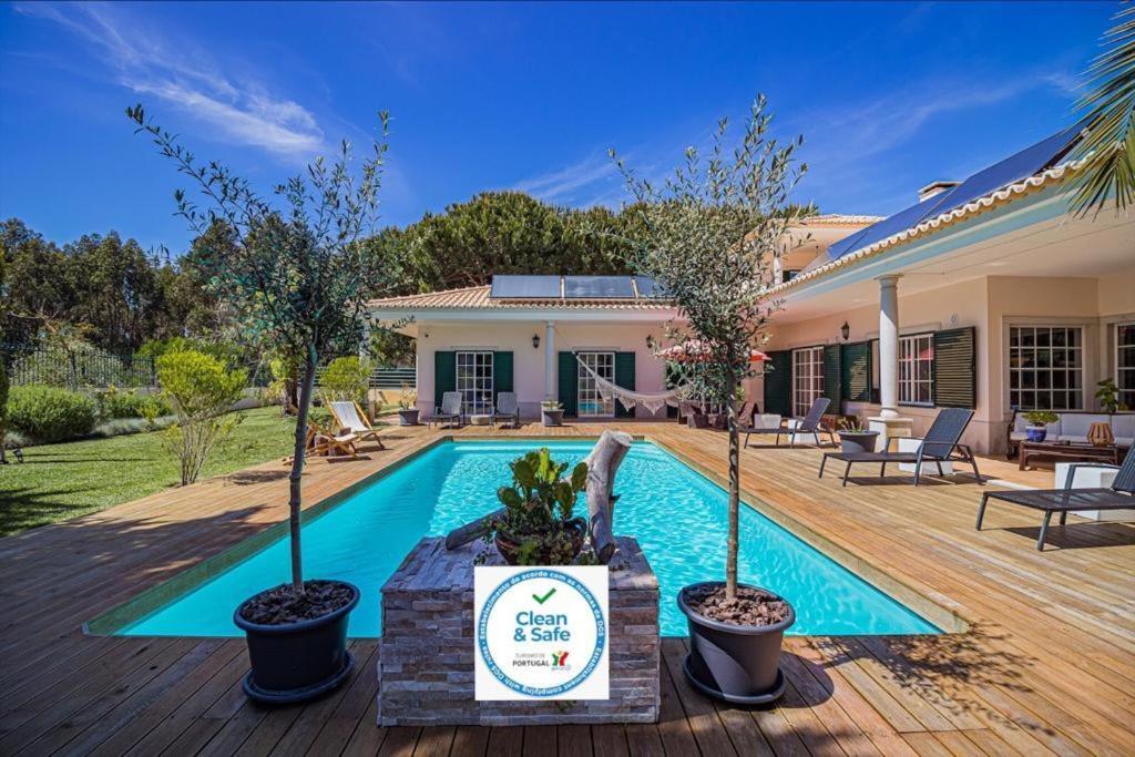 塞辛布拉7 bedrooms villa with private pool enclosed garden and wifi at Sesimbra的庭院中一座带树木游泳池的房子