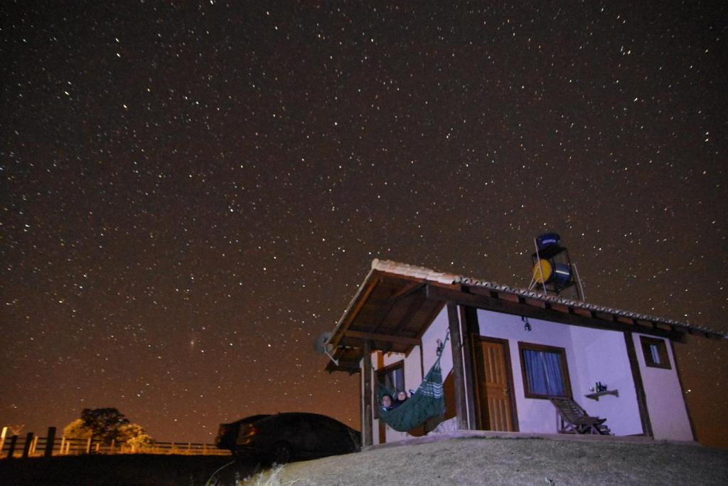 卡兰卡斯Pousada Gaya的鸟坐在星空下的房子顶上