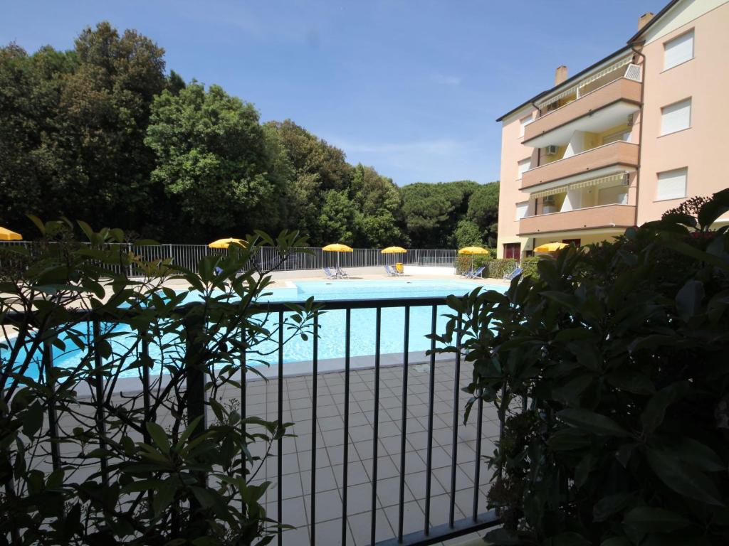 洛萨皮内塔Apartment Acquamarina-3 by Interhome的建筑物旁围栏后面的游泳池