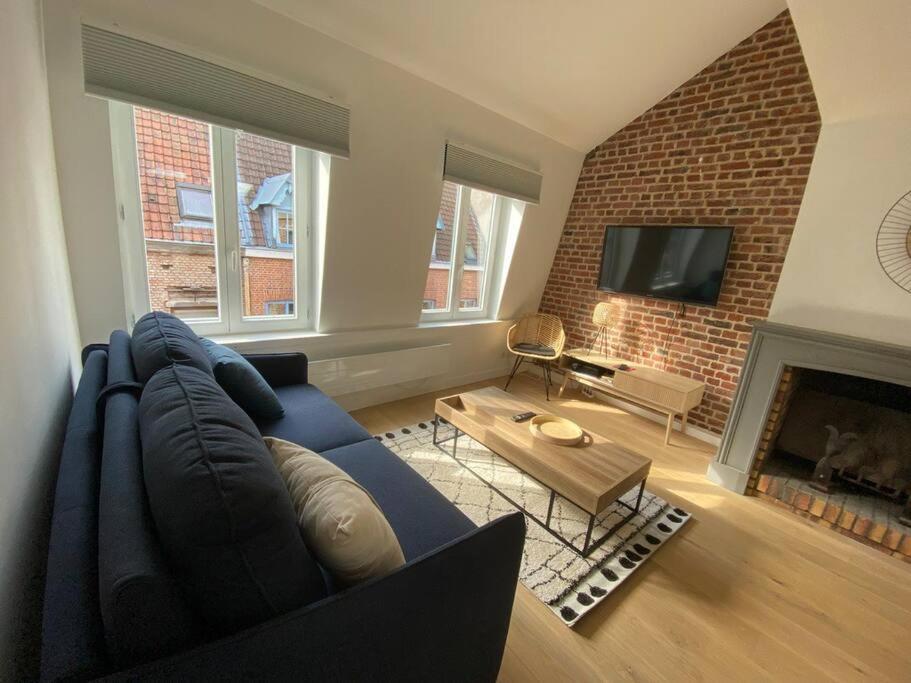 里尔Appartement 50 m2 avec Rooftop Lille Centre的客厅设有蓝色的沙发和壁炉