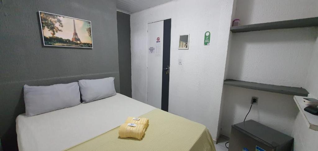 累西腓Casa Aeroporto Pousada的一间小卧室,配有一张白色的床和一张黄色的桌子