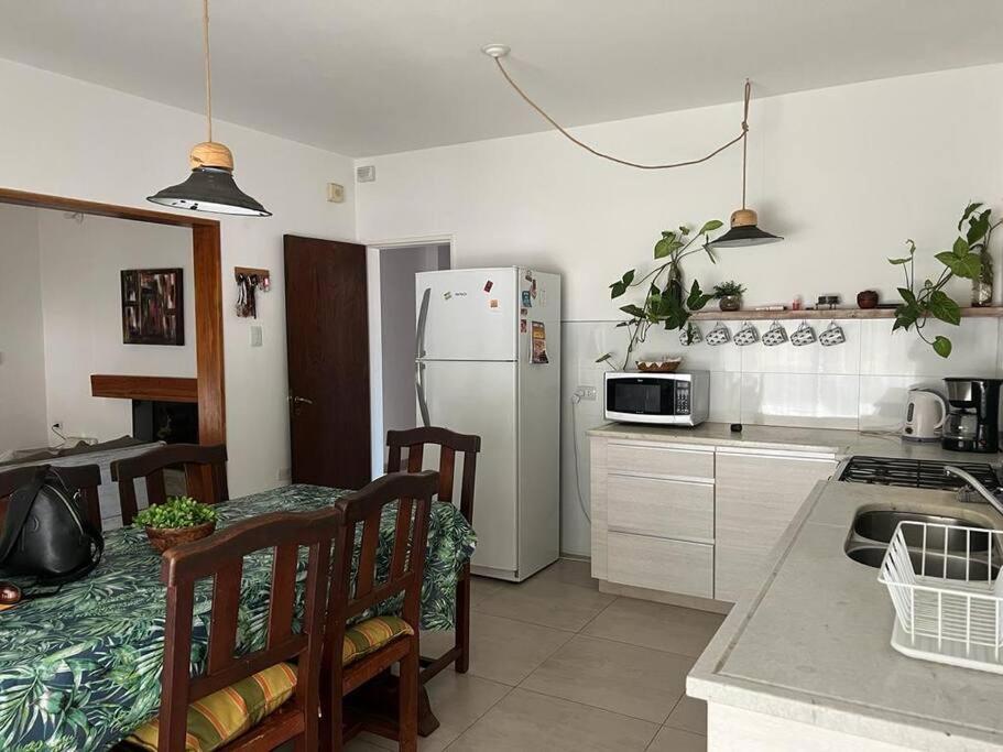 科尔多瓦Alquiler de casa zona Cerro的厨房配有桌子和白色冰箱。