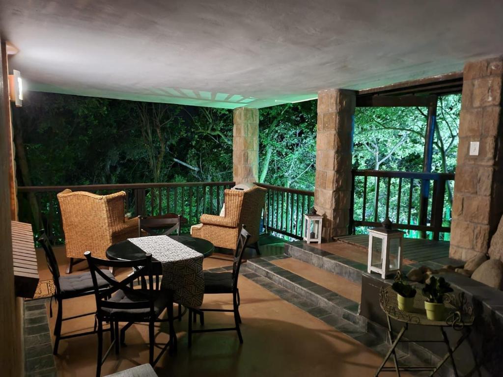 内尔斯普雷特Tranquil Garden Nest的阳台的门廊配有椅子和桌子