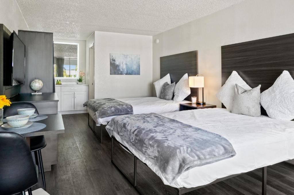 圣奥古斯丁Stayable St Augustine的一间卧室配有两张床、一张桌子和一台电视。
