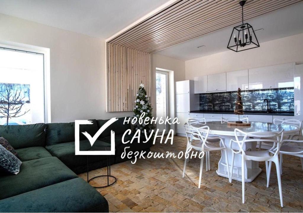 布克维Шале БІЛИЙ ЛЕВ - WHITE LION Chalet的客厅配有绿色沙发和桌子