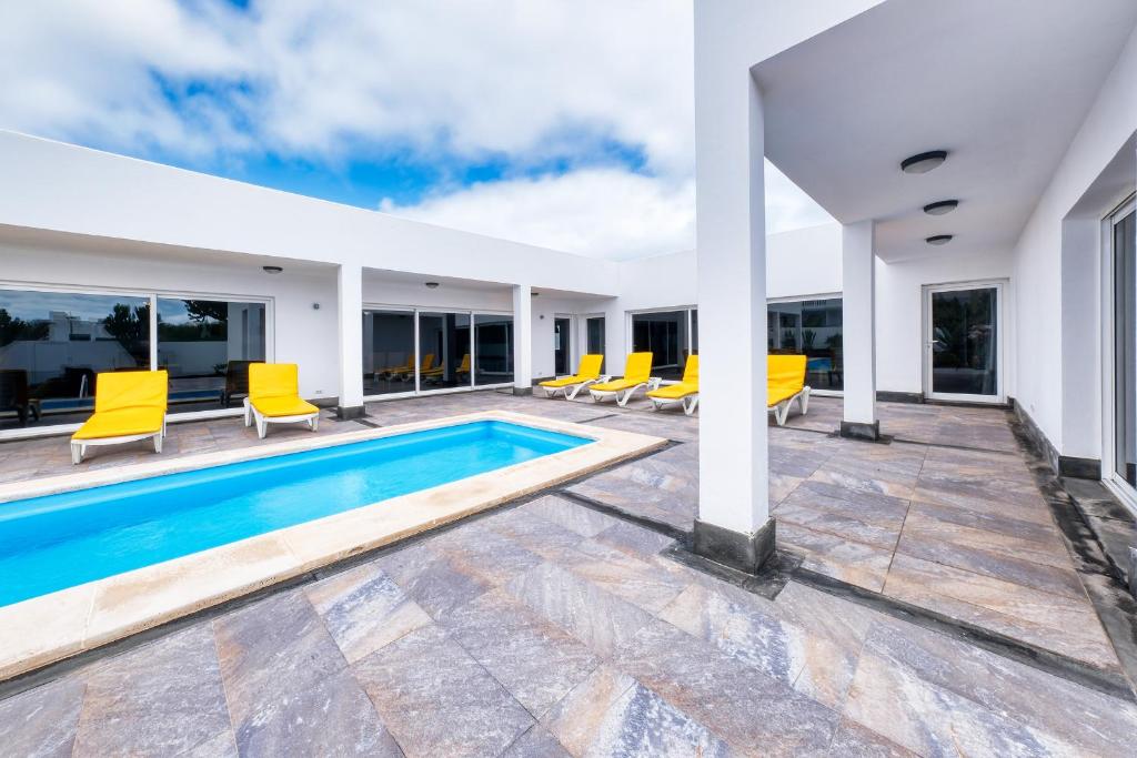 查德尔帕罗奥Casa Eden naturist area, full privacy, relax and private pool的别墅 - 带游泳池和黄色椅子