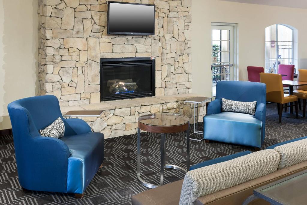 圣安东尼奥圣安东尼奥机场万豪唐普雷斯套房酒店的大堂设有2把蓝色椅子和壁炉