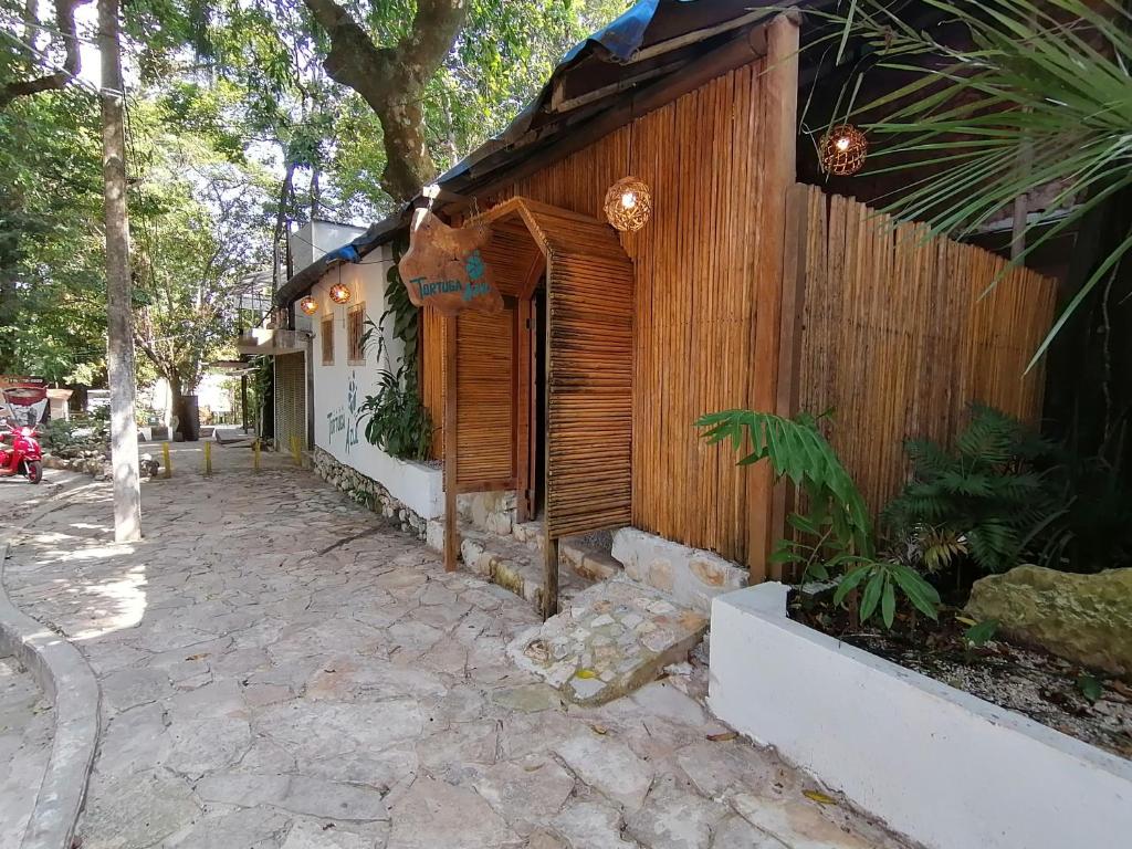 帕伦克Casa Tortuga Azul的一座木结构建筑,前面有一条石头人行道