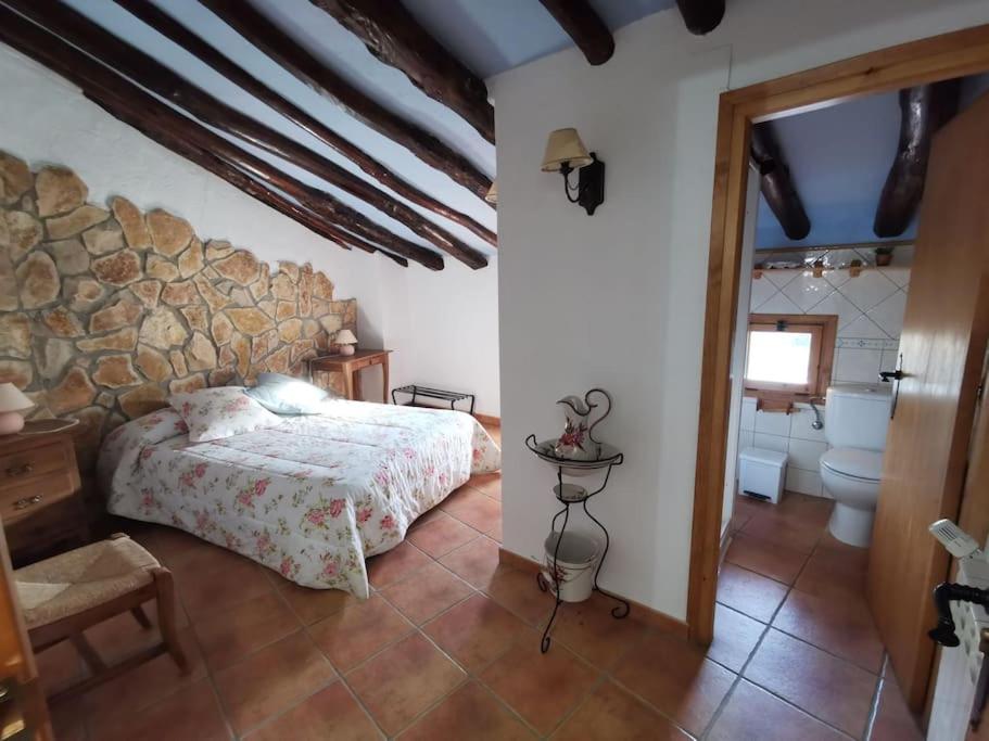 MontalbánCasa Roya的一间卧室设有一张床和石墙