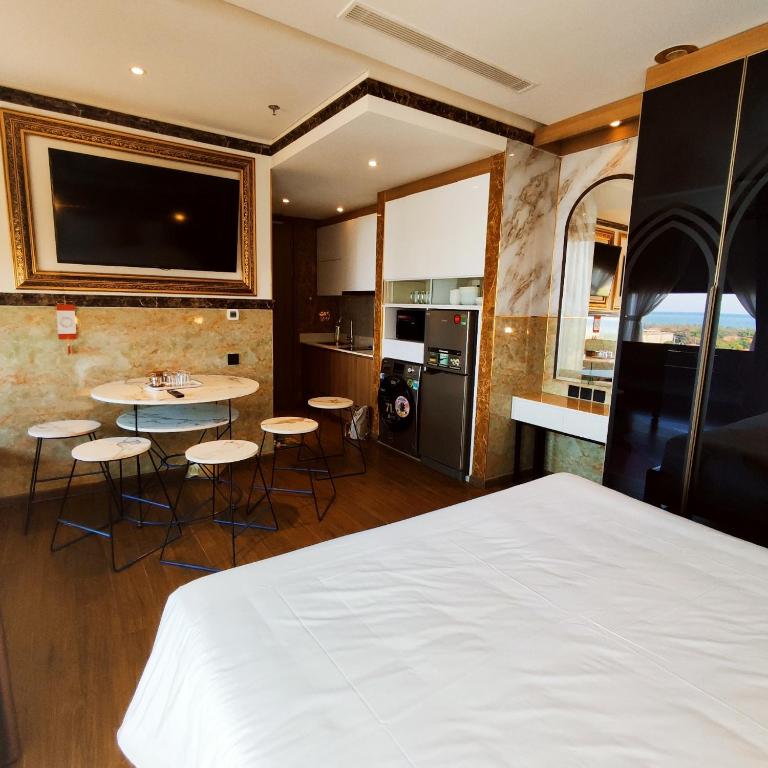 绥和市Beach apartment apec Phú Yên的一间卧室配有一张床,厨房配有桌椅