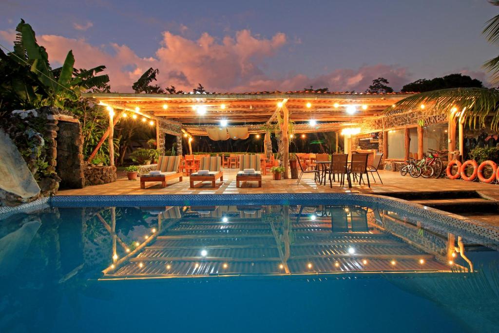 BellavistaNatura Gardens Galápagos的一座带灯光的房屋前的游泳池