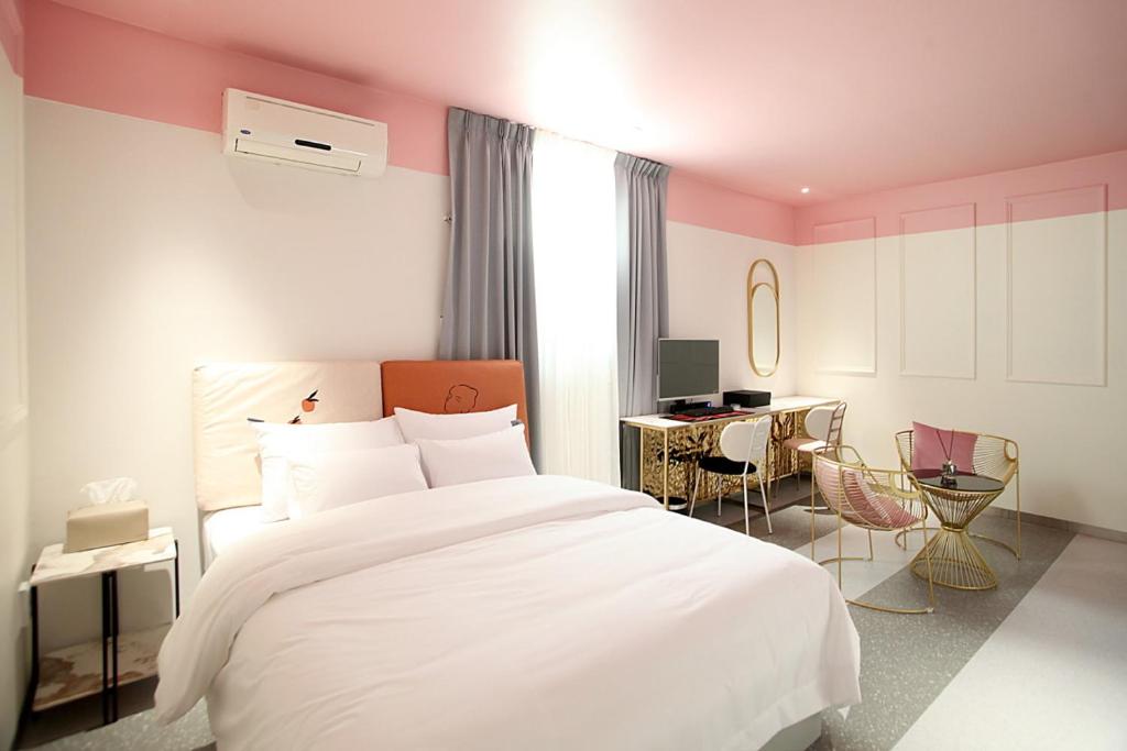 GimcheonBaba Hotel Gimcheon的卧室配有白色的床和书桌