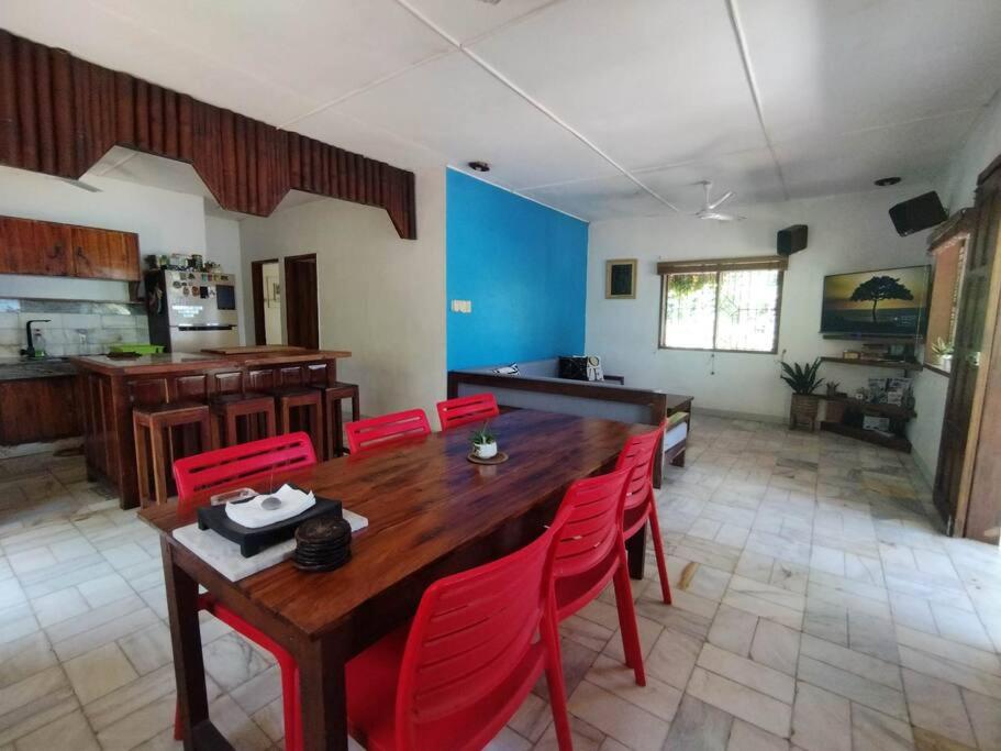 波尔多·格尼拉Transient House的一间带木桌和红色椅子的用餐室