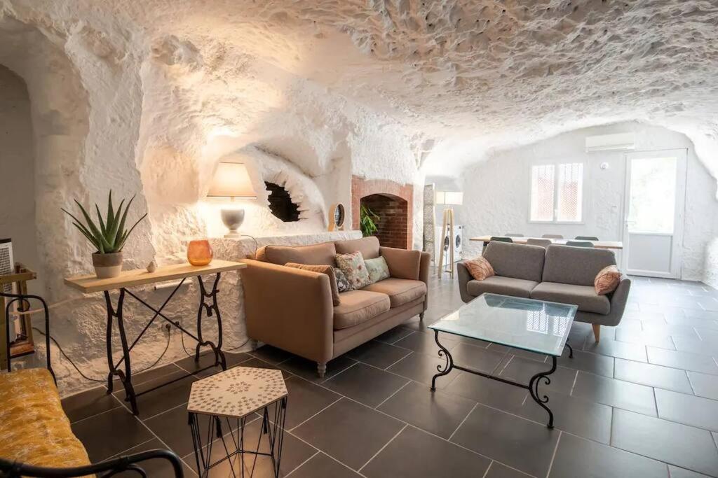 吕讷Maison troglodyte - Le Cerisier Perché的客厅配有沙发和桌子