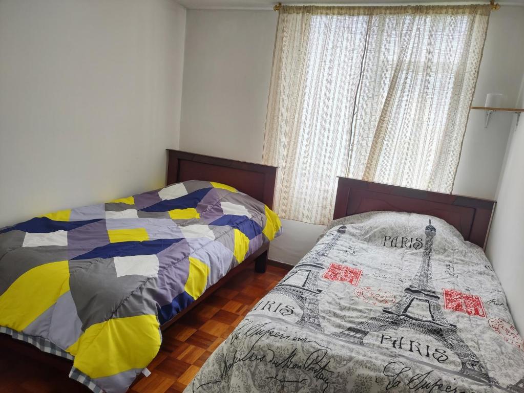 基多Mi Casa的一间卧室设有两张床和窗户。