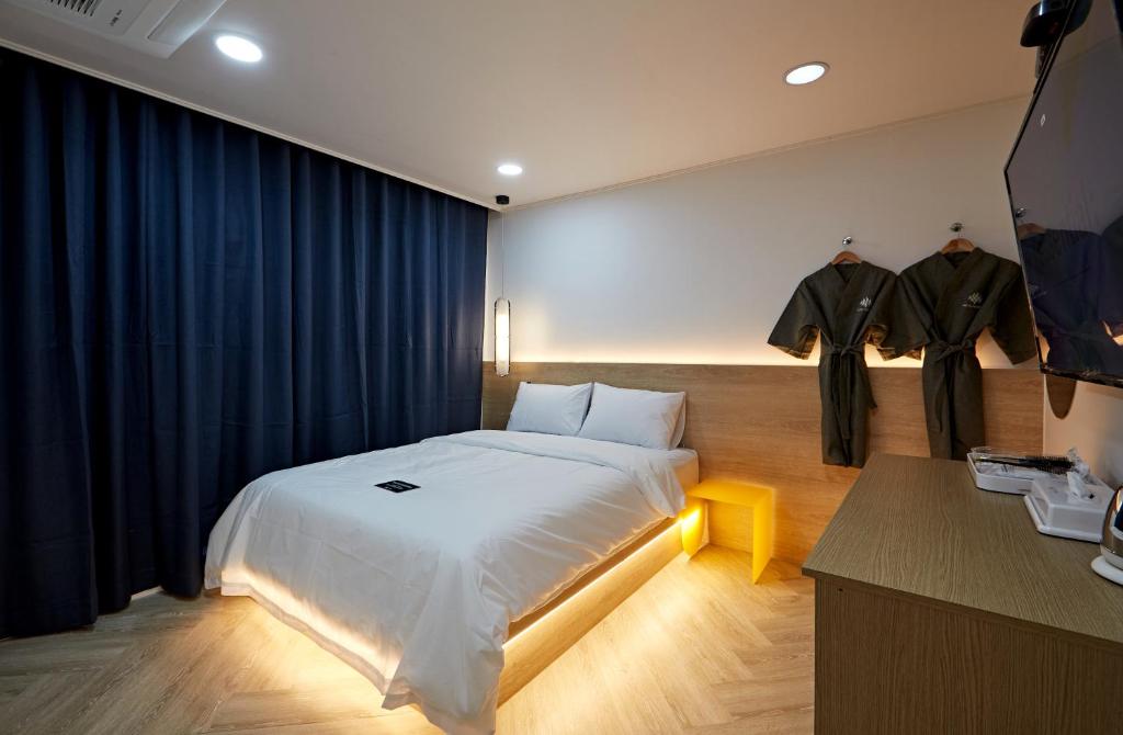 全州市Hotel sounds的一间卧室配有一张蓝色窗帘的大床
