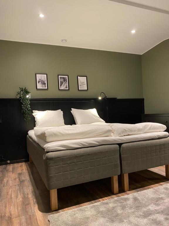 索伦蒂纳Magnolia House Sollentuna的卧室内的一张床位,卧室设有绿色的墙壁