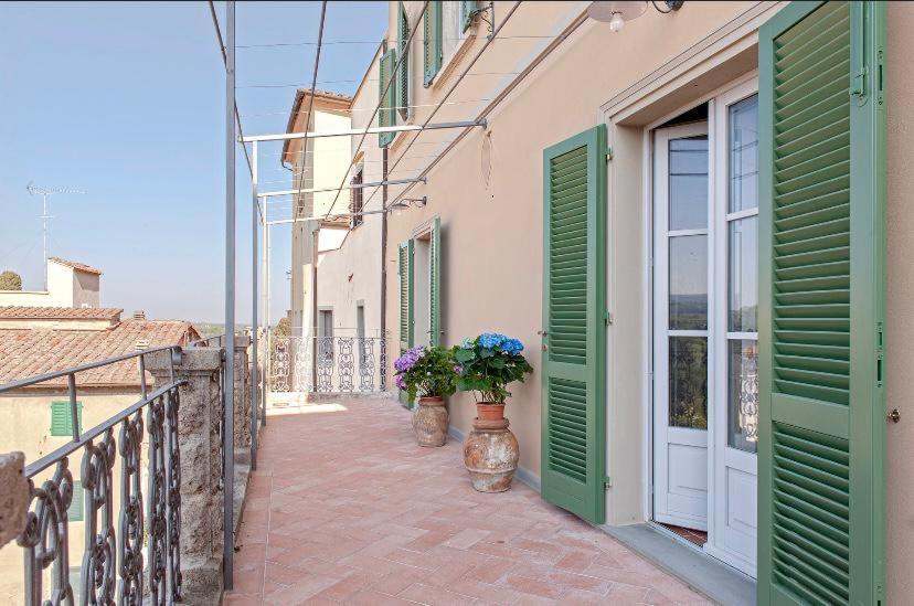 拉里Castellinaria的阳台上带绿门和鲜花的建筑