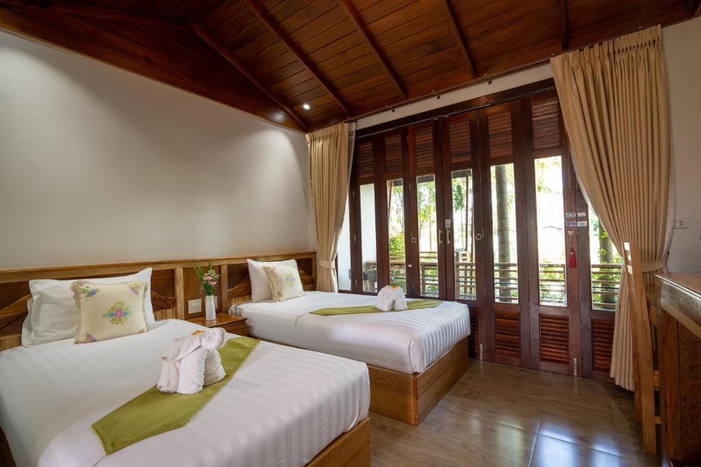 Ban Khok LoMadee Spa & Resort的带窗户的客房内的两张床