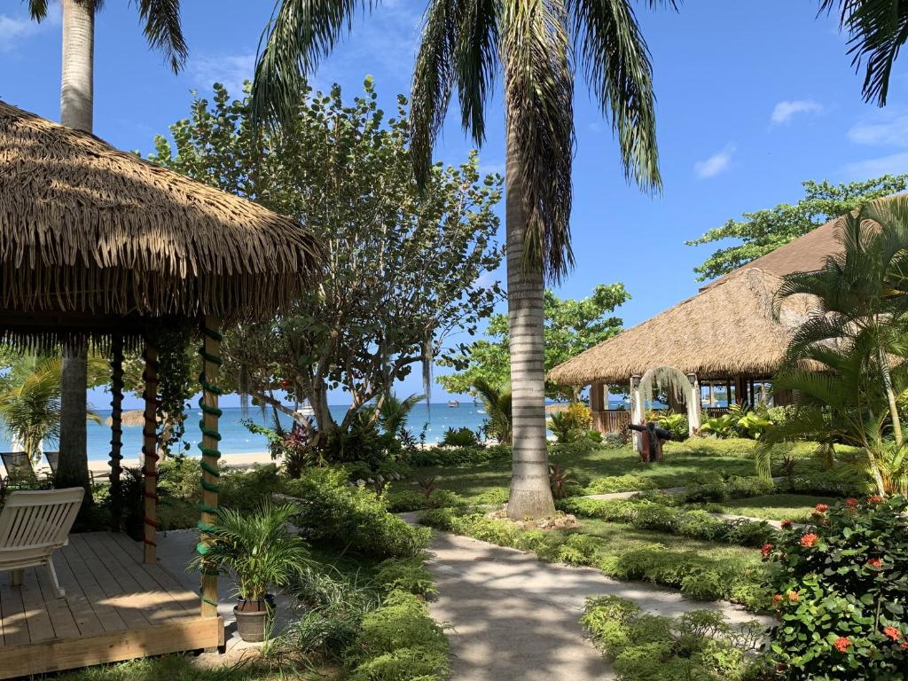 尼格瑞尔Relax in Jamaica - Enjoy 7 Miles of White Sand Beach! villa的拥有路径、棕榈树和海洋的度假胜地