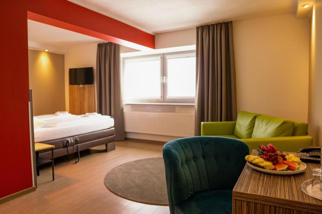 罗斯托克体育论坛酒店的客厅配有床、沙发和桌子