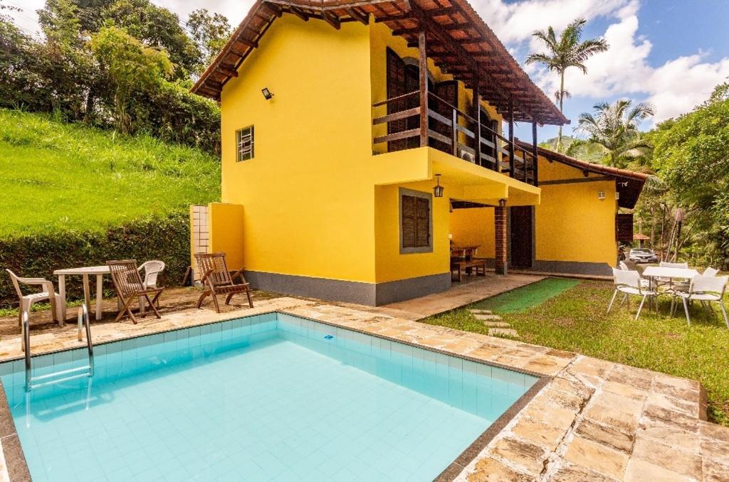 彼得罗波利斯Sítio Borges的房屋前有游泳池的房子