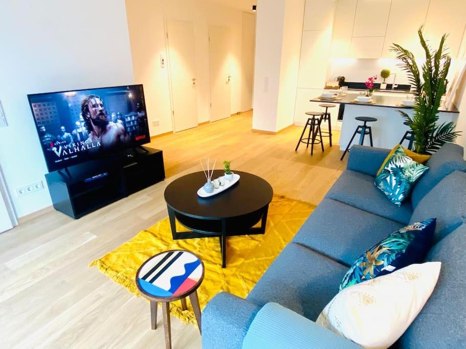卢森堡Luxury Brand New Flat with Terrace & Parking - RTL1的客厅配有蓝色的沙发和电视