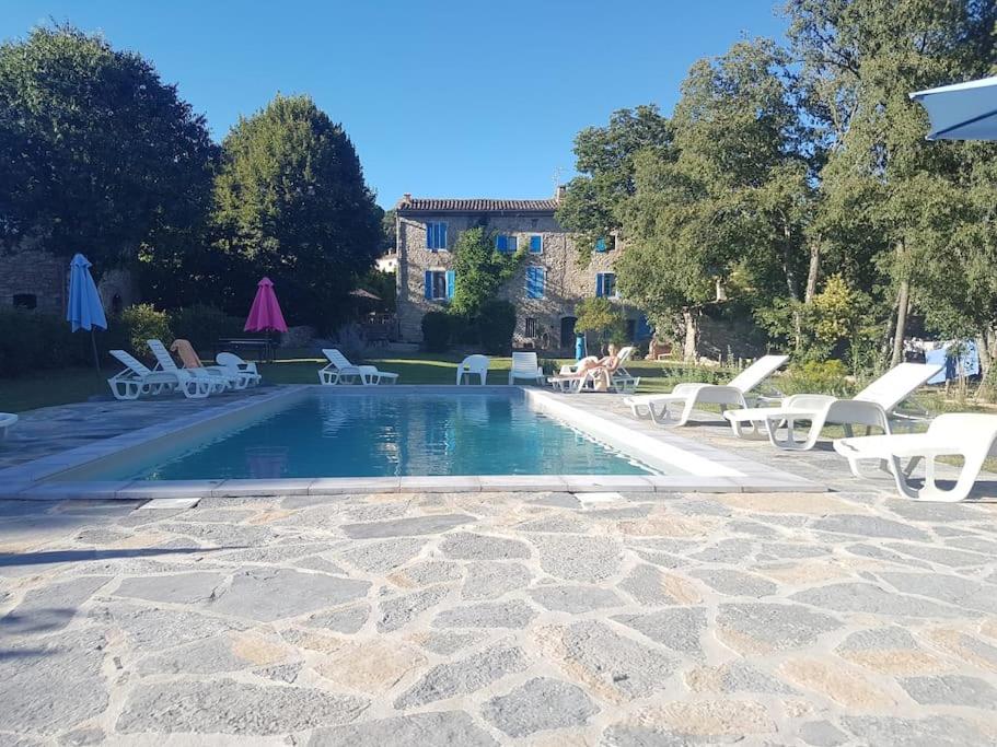 Fressacgrand gîte de charme en Cévennes的一个带白色躺椅的游泳池以及一间房屋