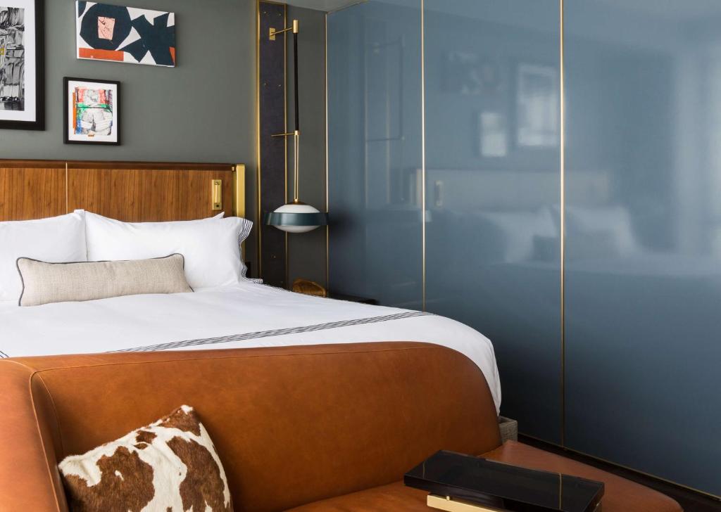 达拉斯Thompson Dallas, by Hyatt的一间卧室配有一张大床和木制床头板