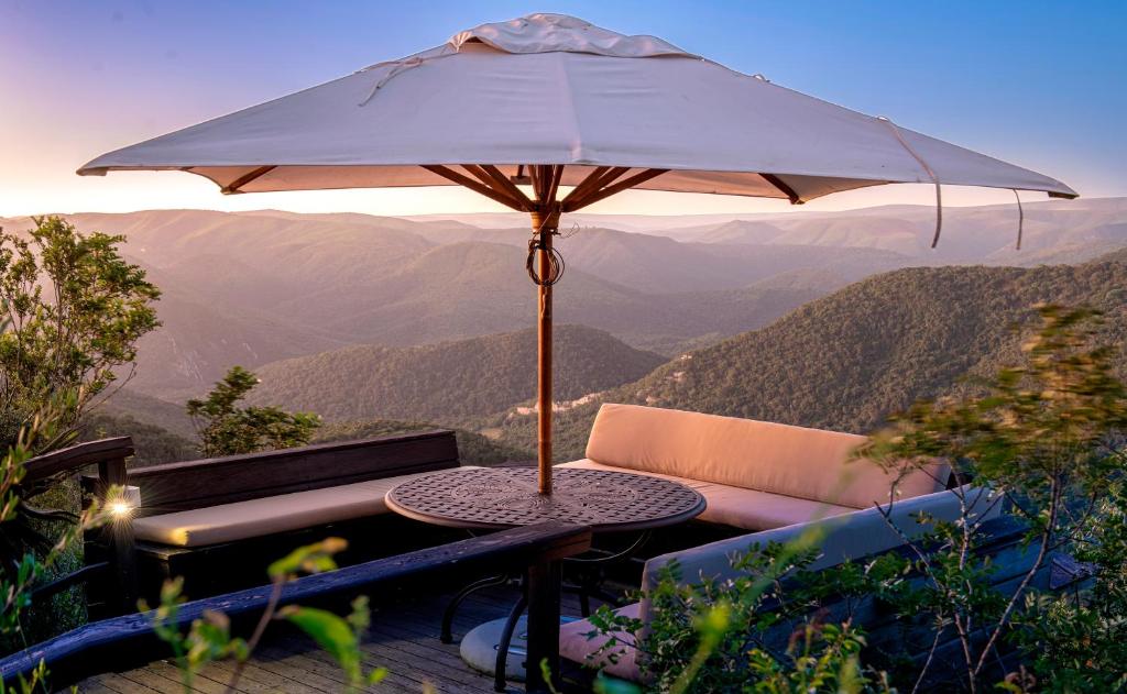 阿多Camp Figtree by The Oyster Collection的山顶上带雨伞的桌子
