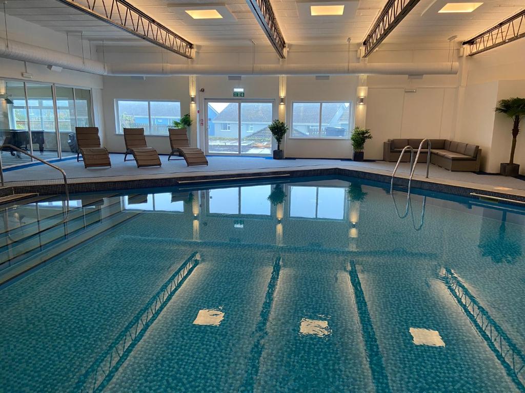 纽基彭迪尔酒店的大楼内带椅子的大型游泳池
