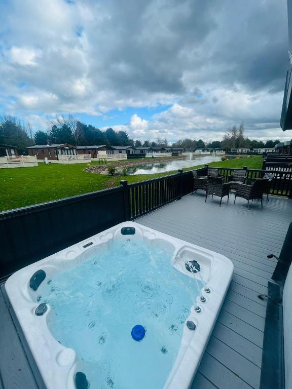 约克Belle Vue Lodge with Hot Tub的河景甲板上的热水浴池