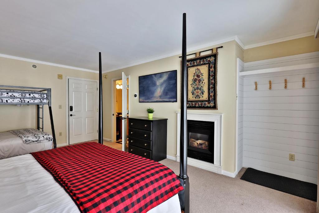 基灵顿The Birch Ridge- Family Room #6 - Queen Bunkbed Suite in Killington, Vermont Hotel Room的一间卧室配有一张床和一个壁炉