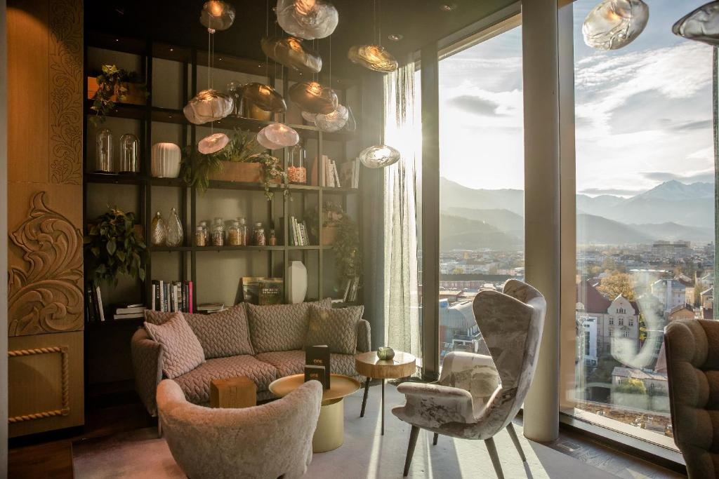 因斯布鲁克Motel One Innsbruck的带沙发和椅子的客厅以及大窗户。
