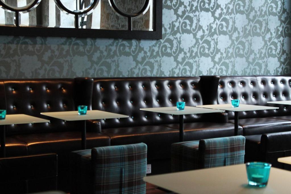 爱丁堡爱丁堡王子一号汽车旅馆的一间带桌子和皮革长凳的用餐室