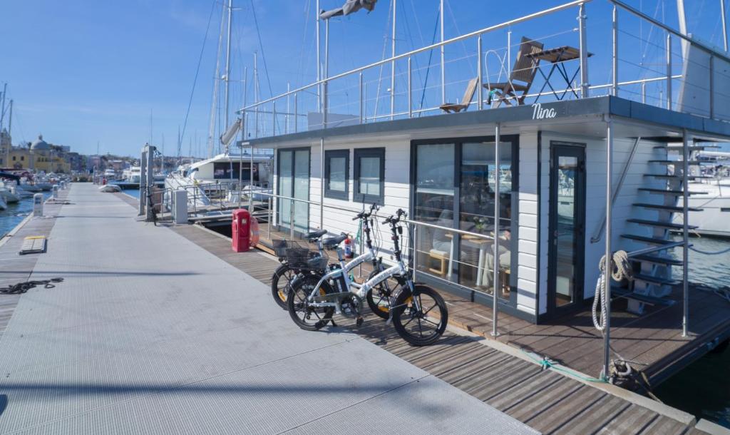 普罗奇达ALMALO Floating House - Casa Galleggiante的两辆自行车停在船边的码头上