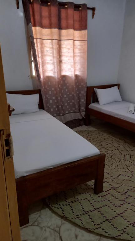 拉穆JAHA的带窗户的客房内设有两张单人床。