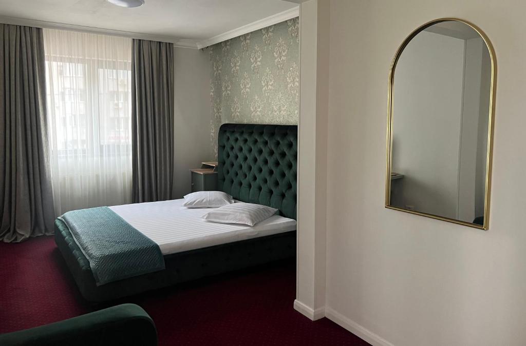 布加勒斯特Eden Boutique Accommodation的酒店客房,配有床和镜子