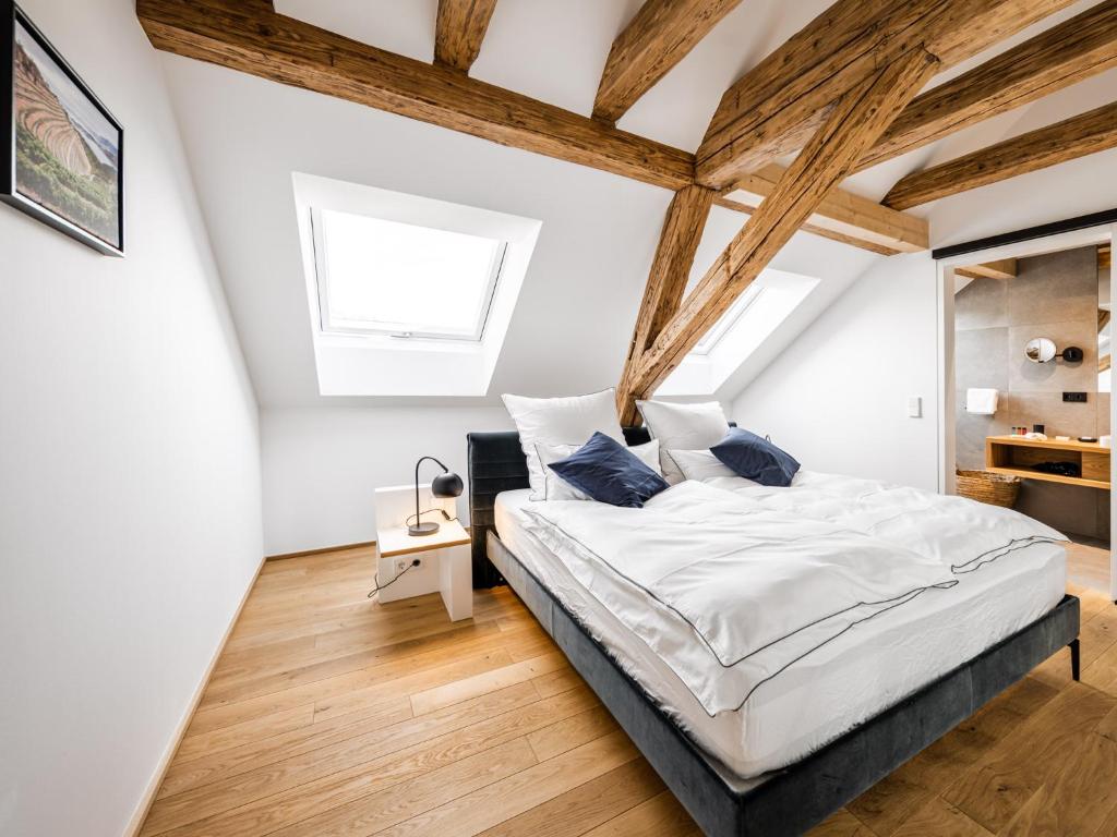 蒂芬巴赫Alte Schule Tiefenbach的卧室拥有白色的墙壁和木梁。