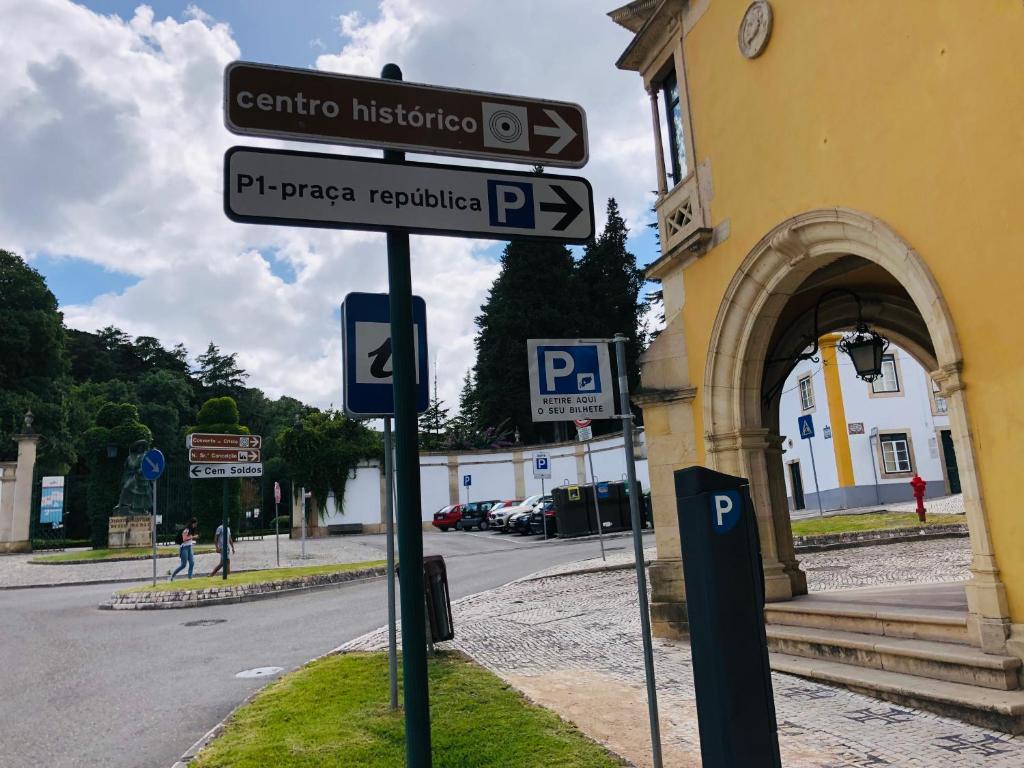 托马尔Pé do Castelo Casinha的建筑前有路标的柱子