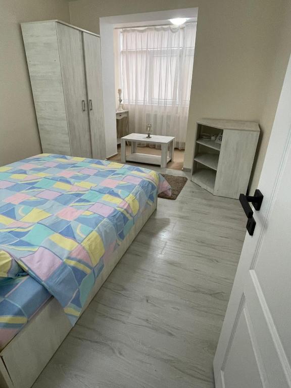 GiurgiuApartament 2 camere ultracentral的一间卧室配有一张带五颜六色棉被的床