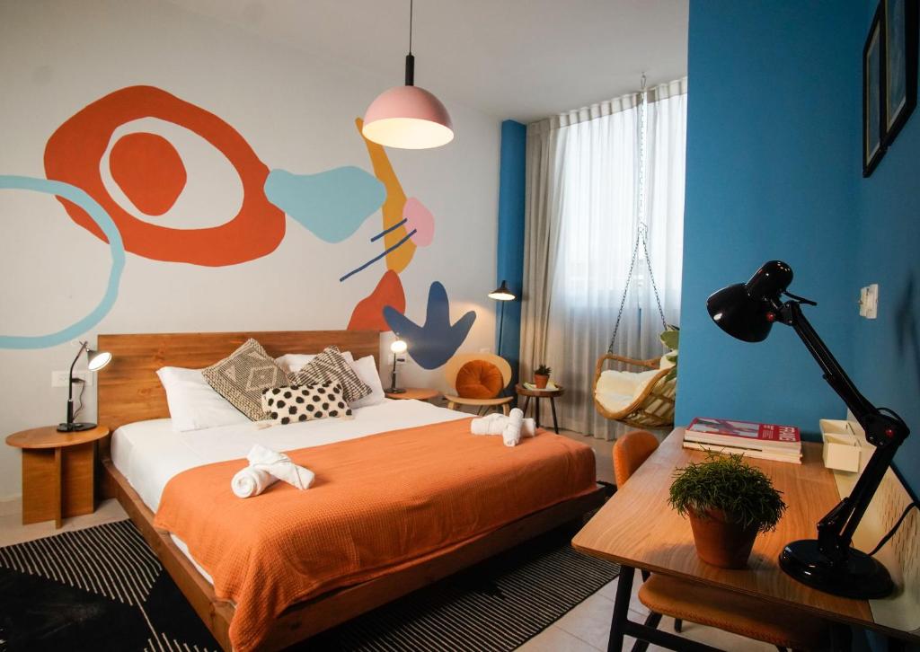 特拉维夫Selina Frishman Tel Aviv的一间卧室配有一张壁画床
